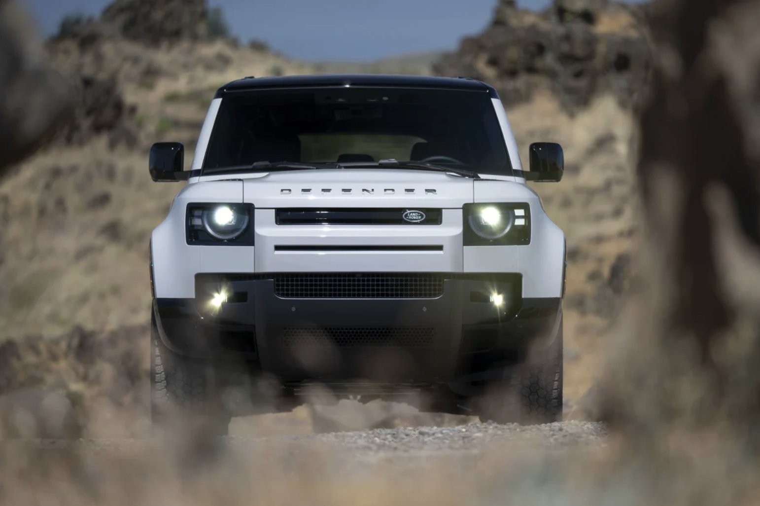 Land Rover Defender 110 head-on with headlamps on